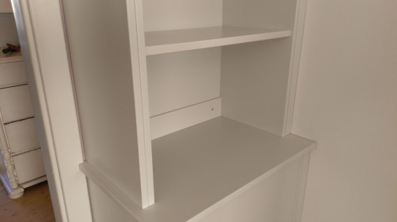 platsbyggd grå bokhylla med bänkskåp måttanpassad mot väggar och dörröppning